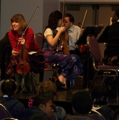 Violinists Rebecca and Mari prepare to play
